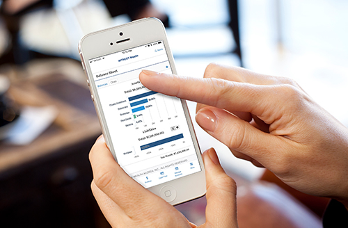 photo-wealth_access_mobile-500x328 Hands holding an iPhone displaying Webster International Wealth Access