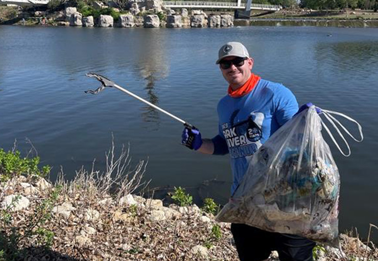 Employee cleaning up the Arkansas River